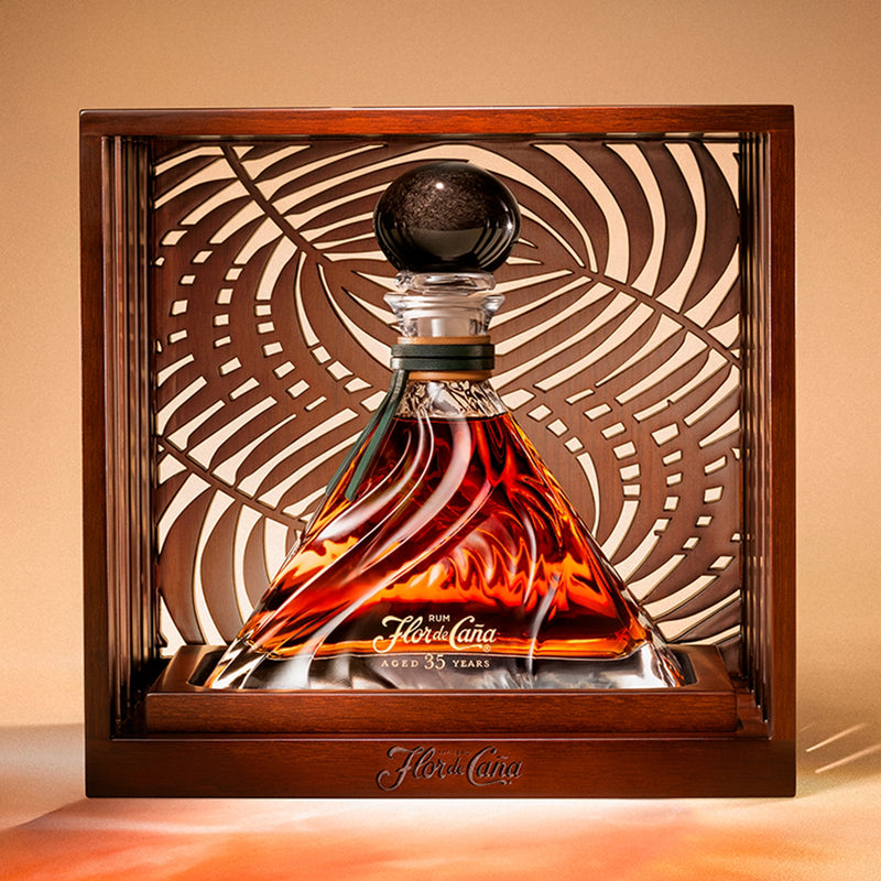 Flor de Cana rum decanter in a wooden display case with a decorative background