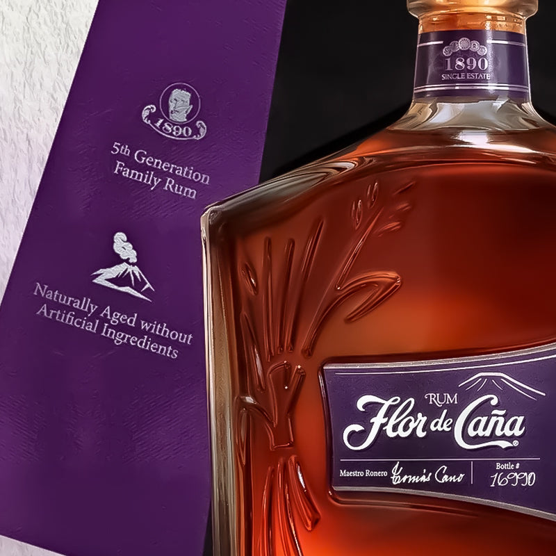 Bottle of Flor de Caána rum with a purple box in the background